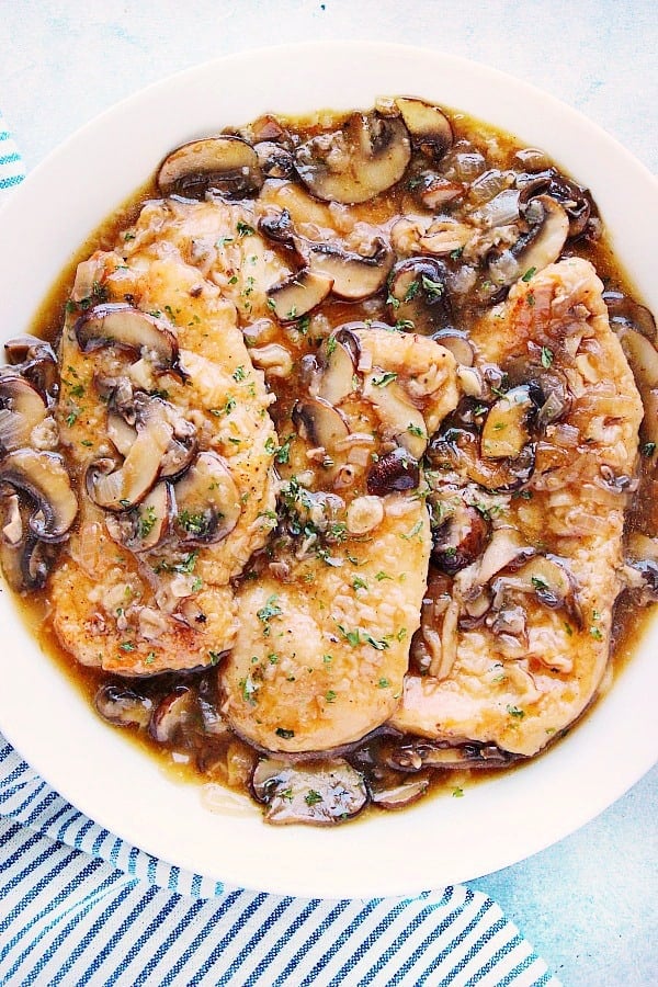 Chicken breasts in a Marsala wine mushroom sauce, on a plate.