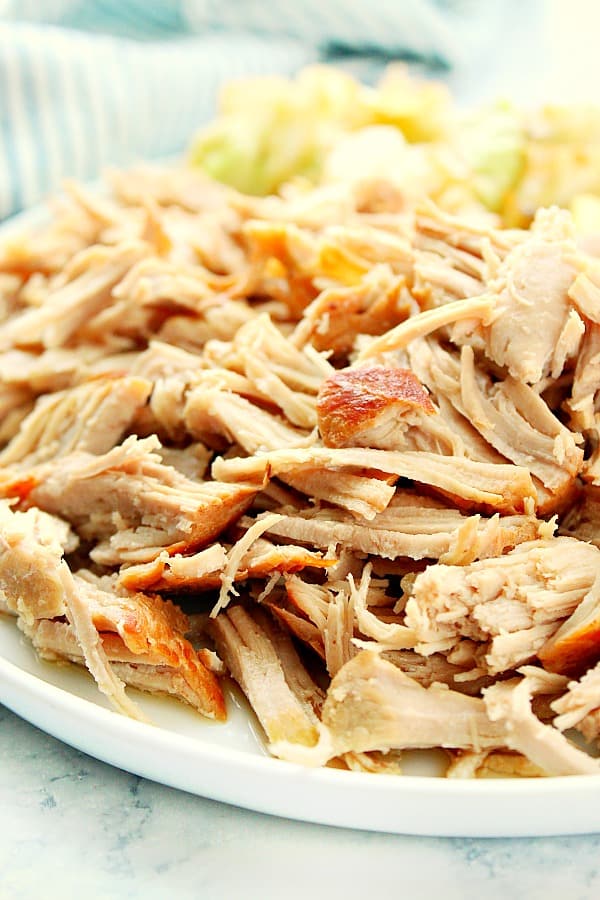 Instant Pot Kalua Pork on a white plate with cabbage on the side.