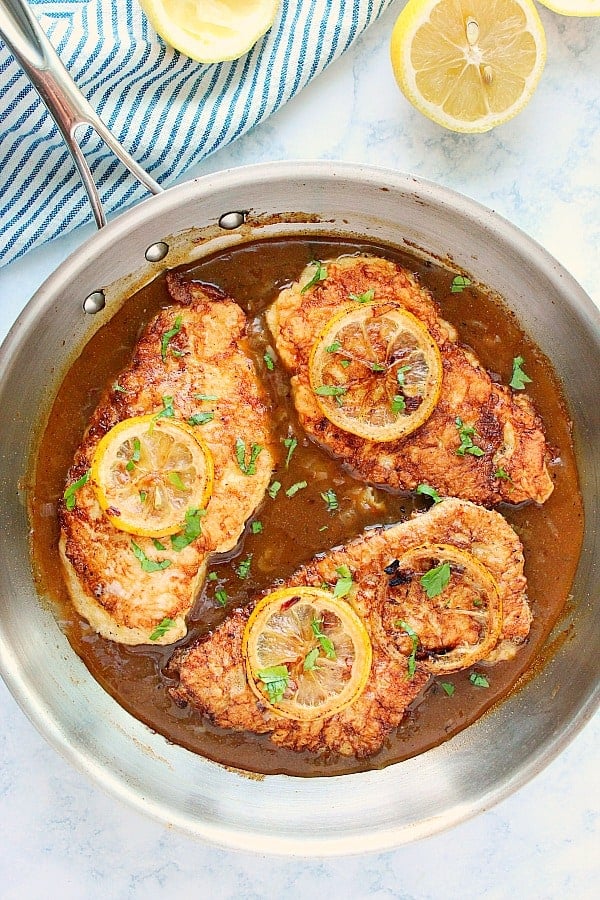 Three Chicken Francese pieces in stainless steel pan.