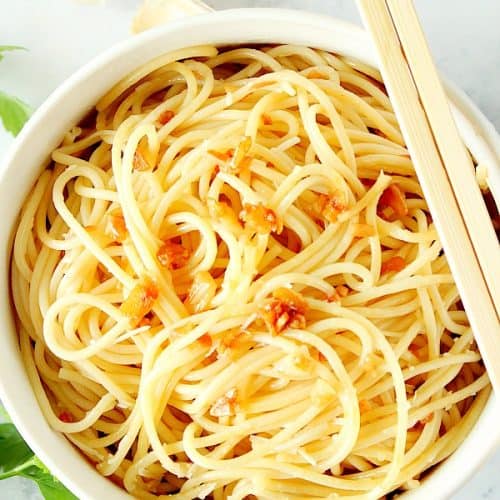 Garlic Noodles in a white bowl with chopsticks.
