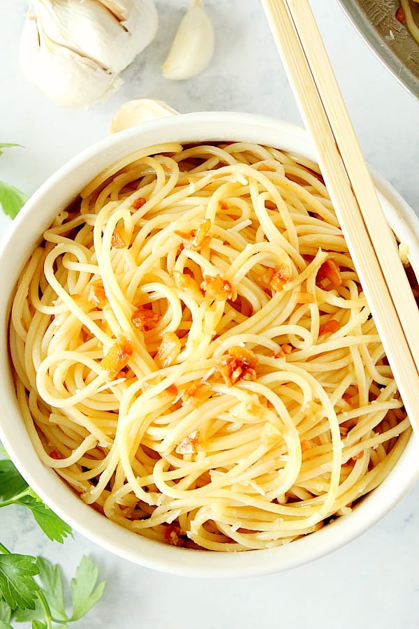 Garlic Noodles in a white bowl with chopsticks.