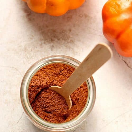 Pumpkin Pie Spice in small jar with wooden spoon.