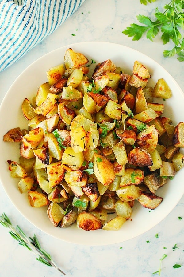 Roasted Rosemary Potatoes - quick and easy vegetable side dish with lots of flavors! Serve with any main dish or use to make roasted veggie bowls with grains. Roasted Rosemary Potatoes in a white bowl.