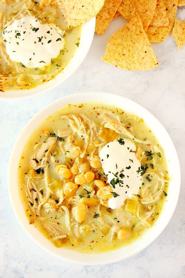 Instant Pot White Chicken Chili in a white bowl with tortilla chips on the side.