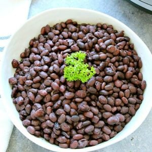Cooked black beans in a white bowl.