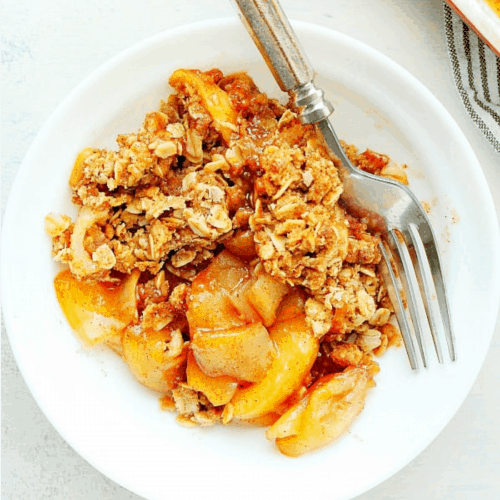 Apple crisp in a white bowl.