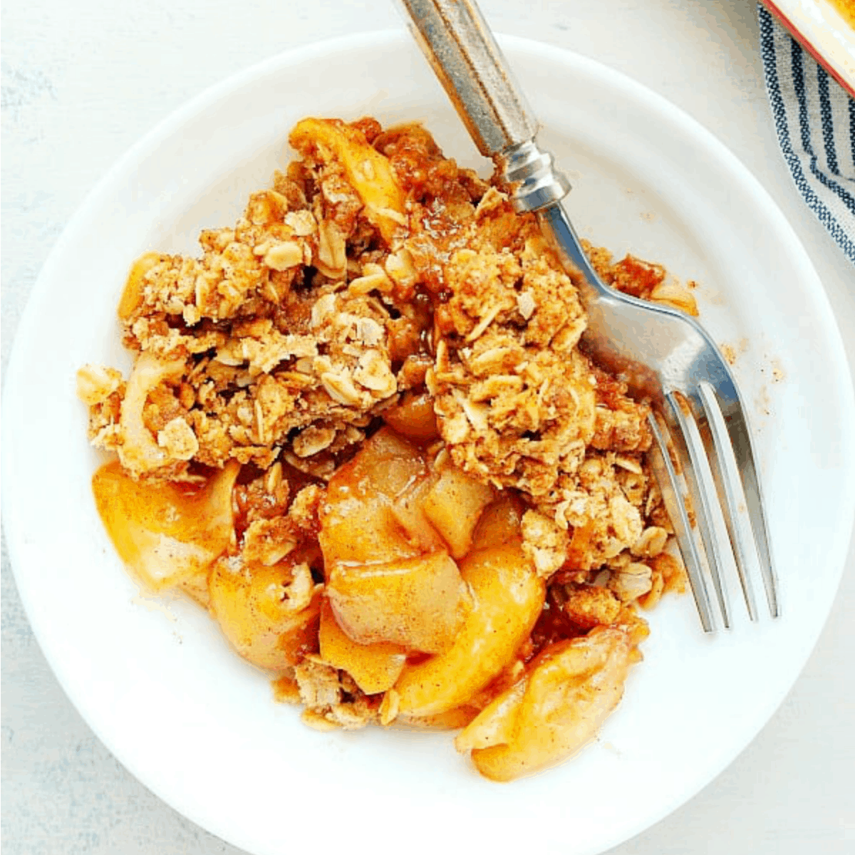 Apple crisp in a white bowl.