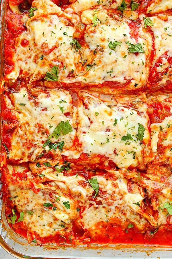 This vegetarian Eggplant Lasagna is perfect for a meatless dinner. It's filled with flavorful vegetable sauce, cheesy ricotta filling and topped with mozzarella. Eggplant Lasagna in a glass baking dish.