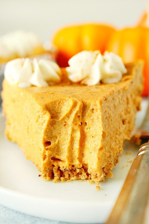 A slice of No Bake Pumpkin Pie on white plate with fork.