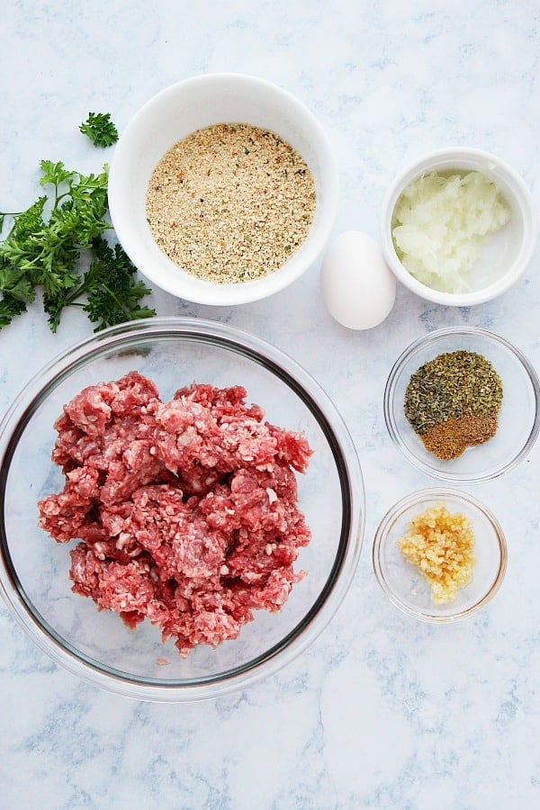 Greek meatballs ingredients on a marble board.