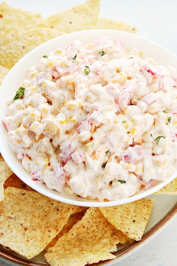 Corn Dip in a bowl with tortilla chips around.