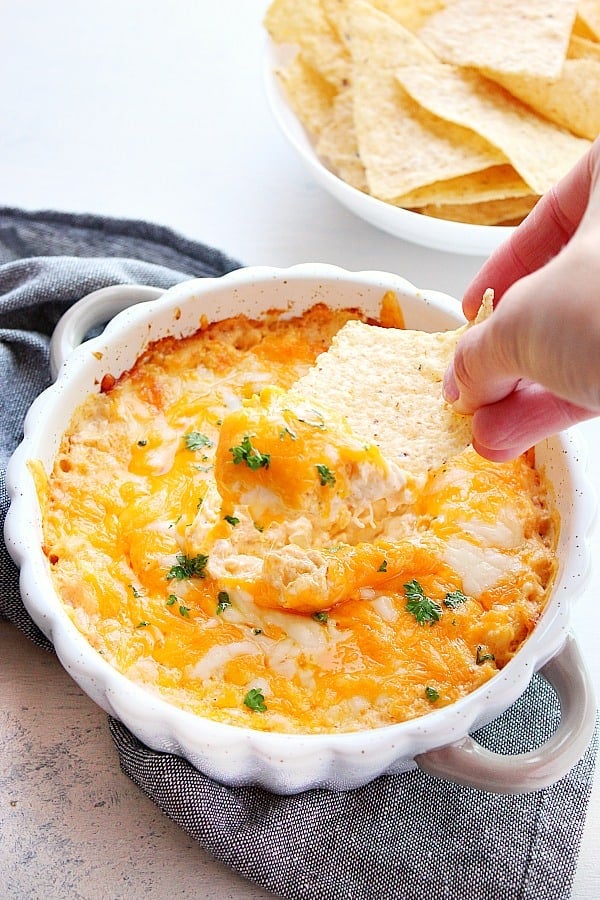 Hot Crab Dip with tortilla chip dipped in it.