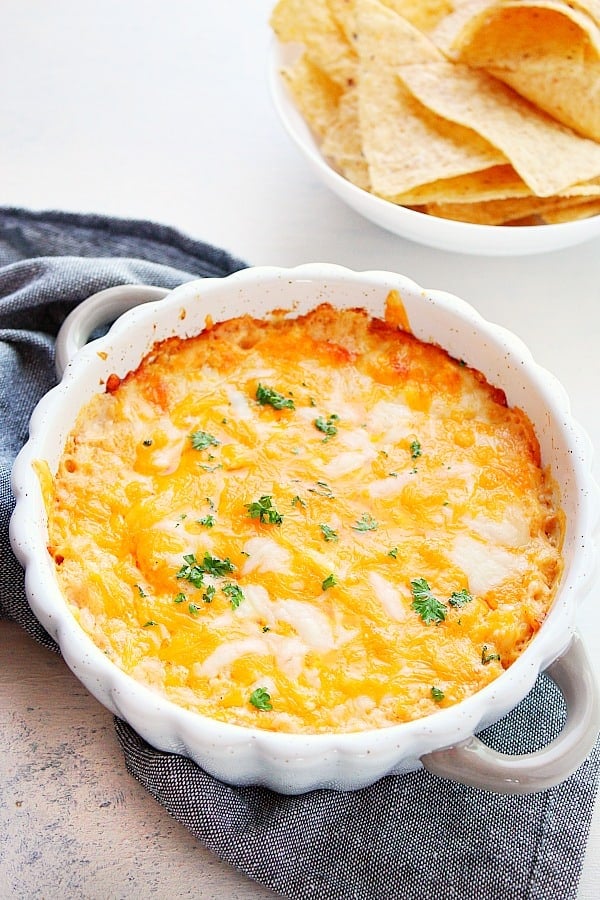 Hot Crab Dip - creamy and cheesy dip with crab meat, cream cheese and cheddar. Perfect appetizer for seafood fans! Hot Crab Dip in a round baking dish.