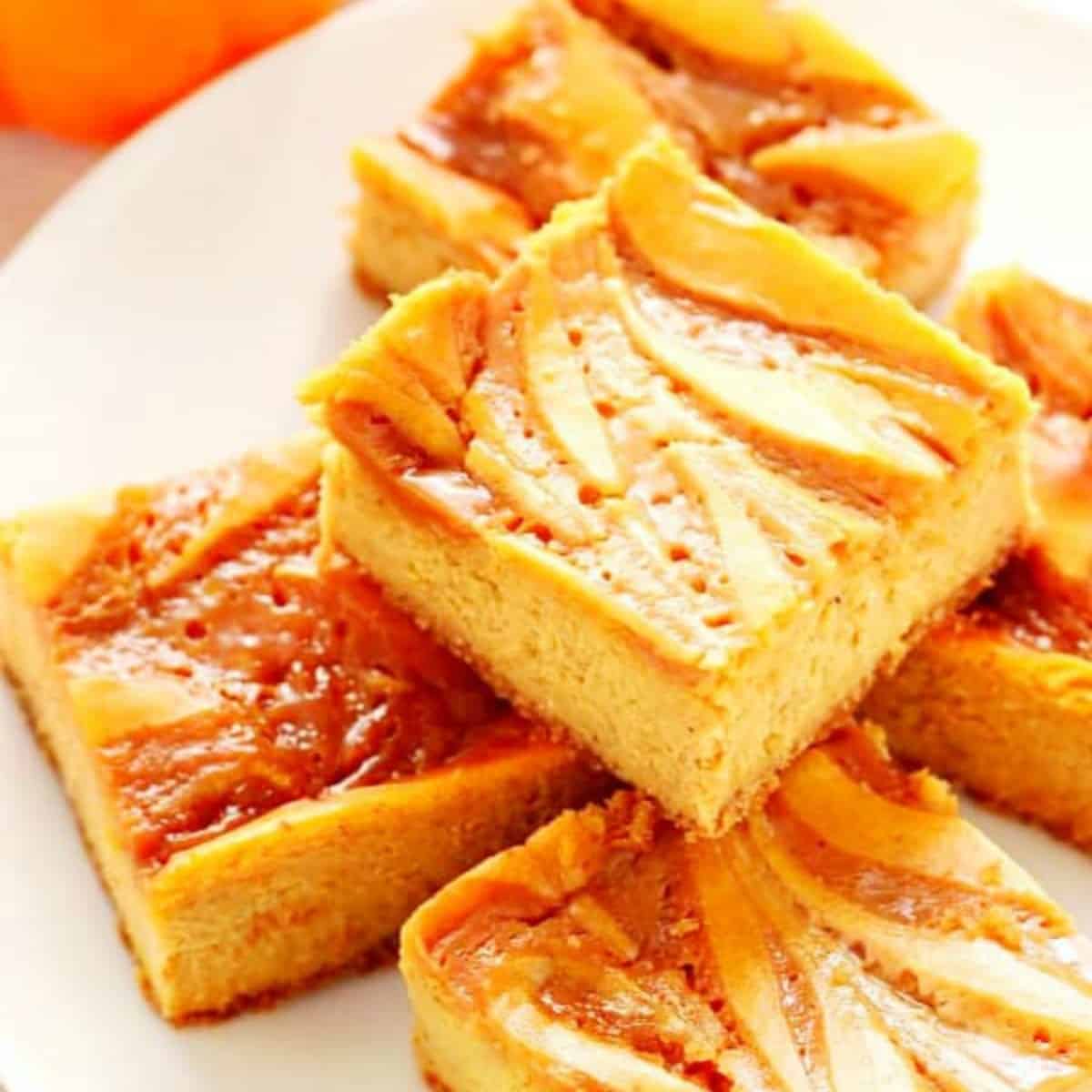 Pumpkin cheesecake bars on a plate.