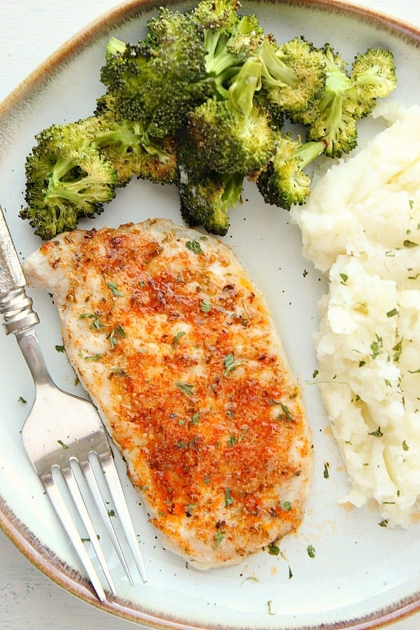 Baked Pork Chop with potatoes and broccoli on a plate.