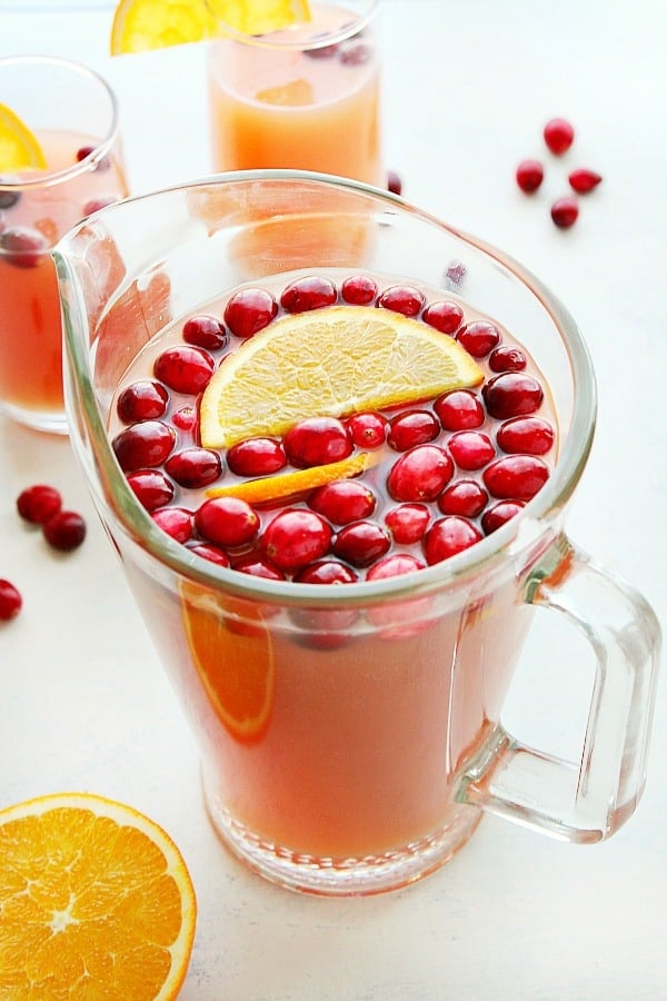 This Christmas Punch is the best holiday drink for the whole family! Christmas Punch in a glass pitcher.