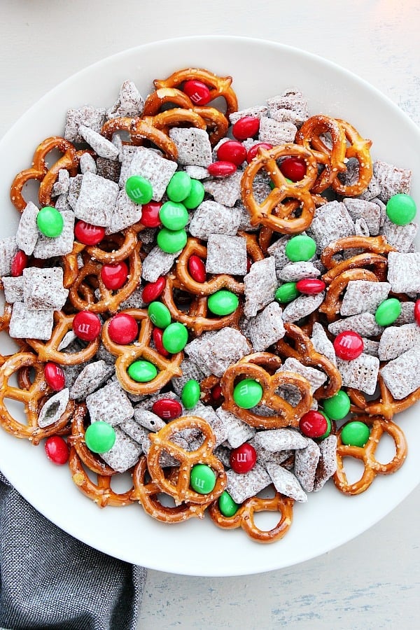 This Reindeer Chow is a 3-ingredient Christmas treat made with chex cereal, pretzels and M&M's candy. Reindeer Chow in a white bowl.