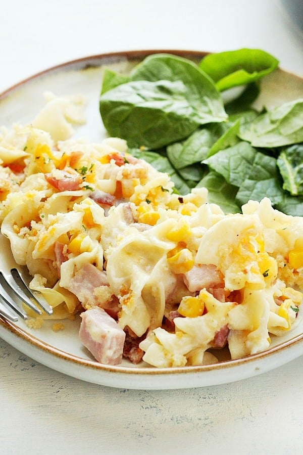 Ham Casserole with spinach salad on a plate.