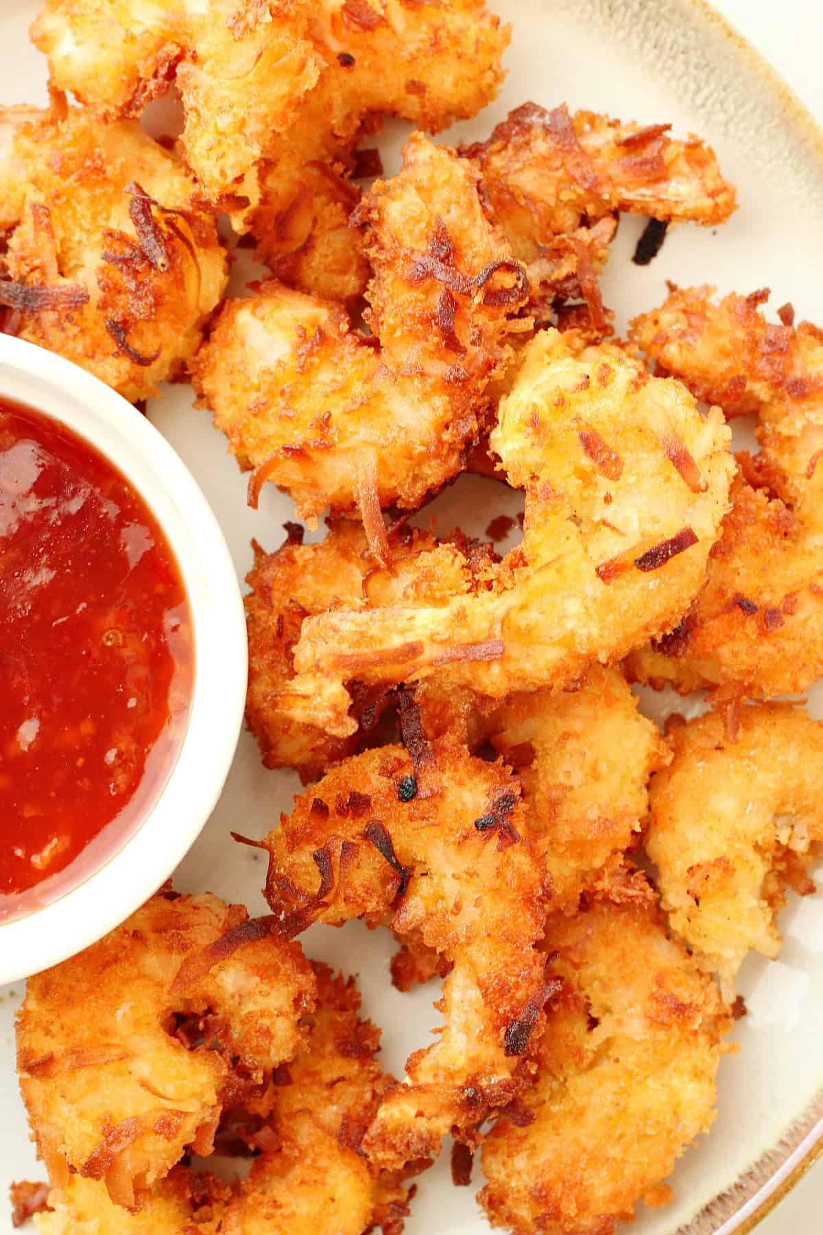 Coconut shrimp with sauce on a plate.