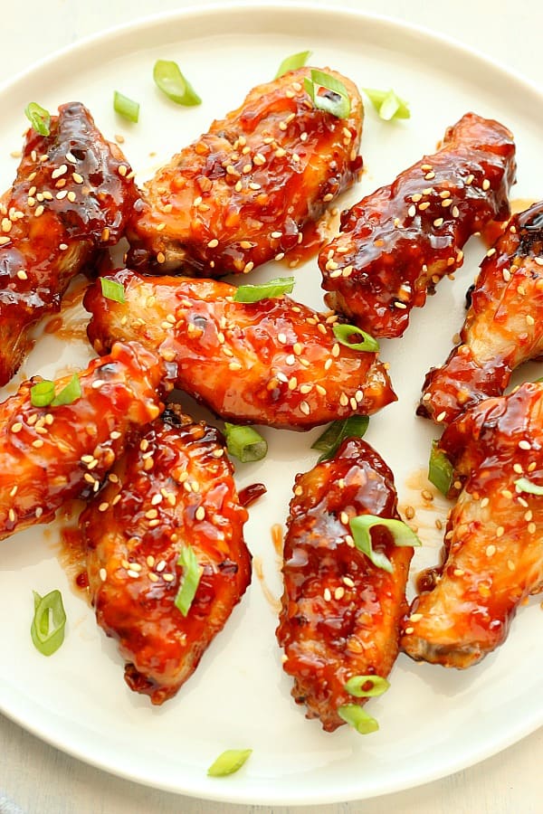 Asian chicken wings on a white round plate.