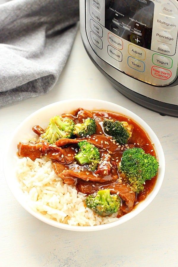 Beef and Broccoli in a white bowl next to the Instant Pot.