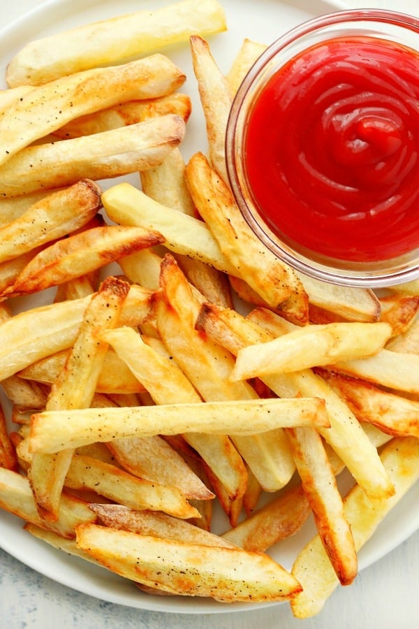 French fries on plate with ketchup.