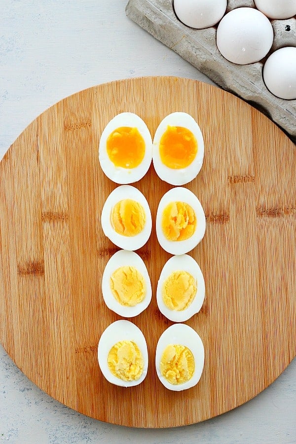 Soft and hard-boiled eggs on a board.