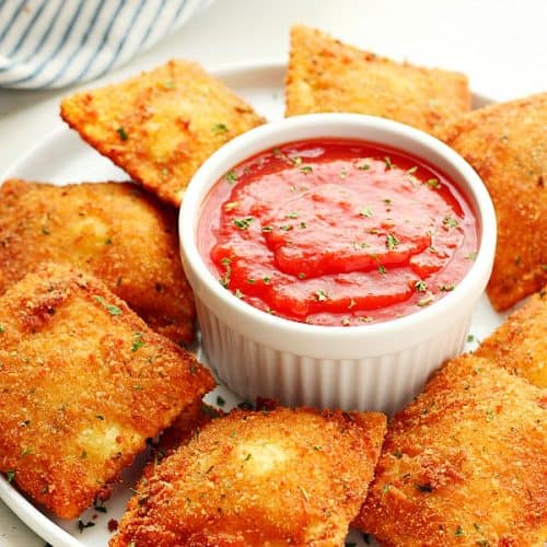 Fried Ravioli with sauce on plate.