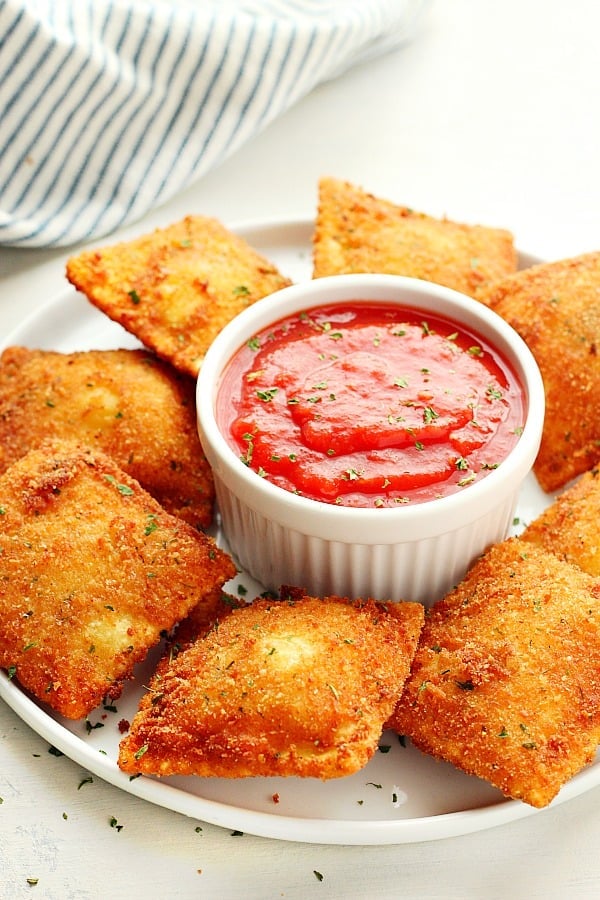 Fried Ravioli pasta with marinara sauce on plate.