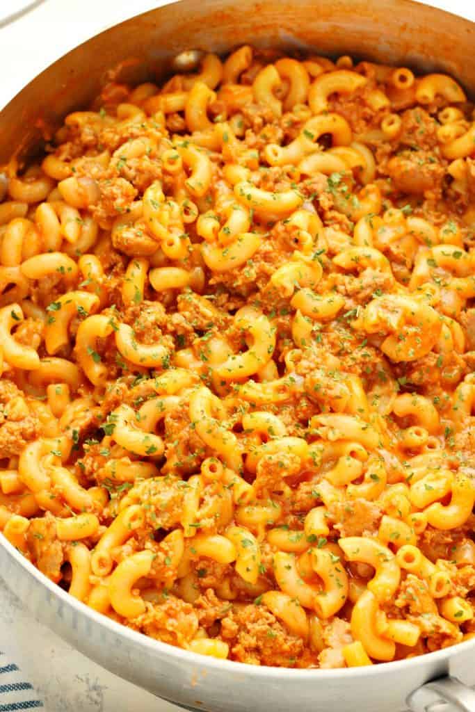 Macaroni with beef in a stainless steel skillet.