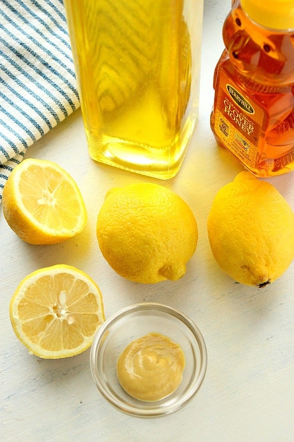 Lemons, oil and honey on a white board.