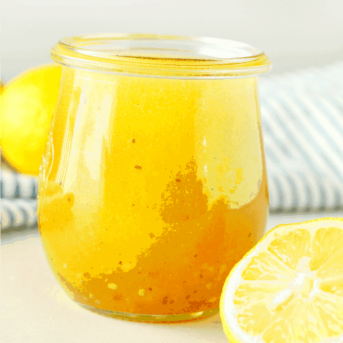 Salad dressing with lemons in a small jar.