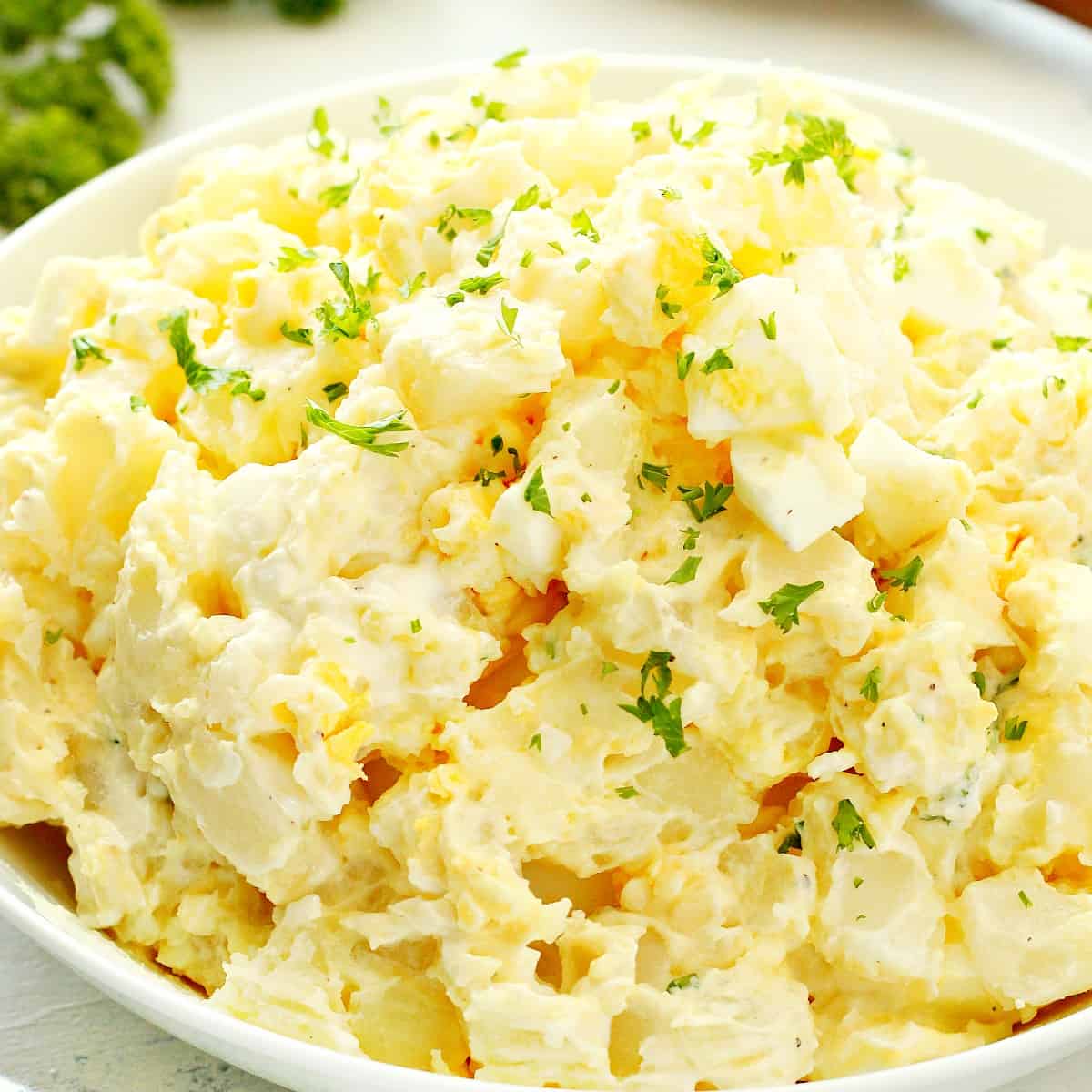 Potato salad in a white bowl.