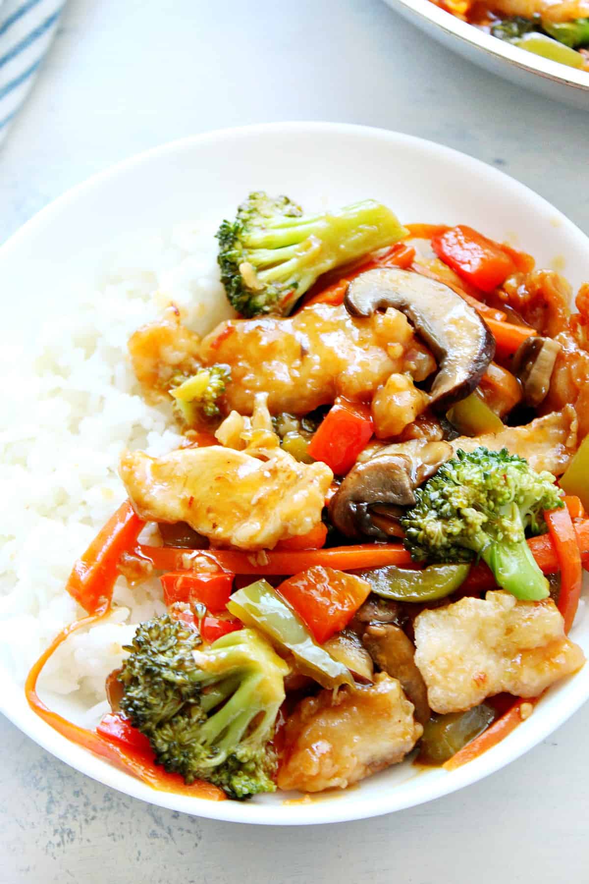 Chicken and veggies with rice in a bowl.