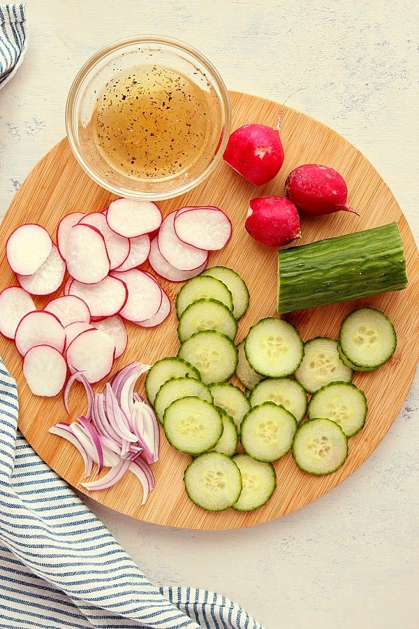 Ingredients for radish salad on a cutting board.