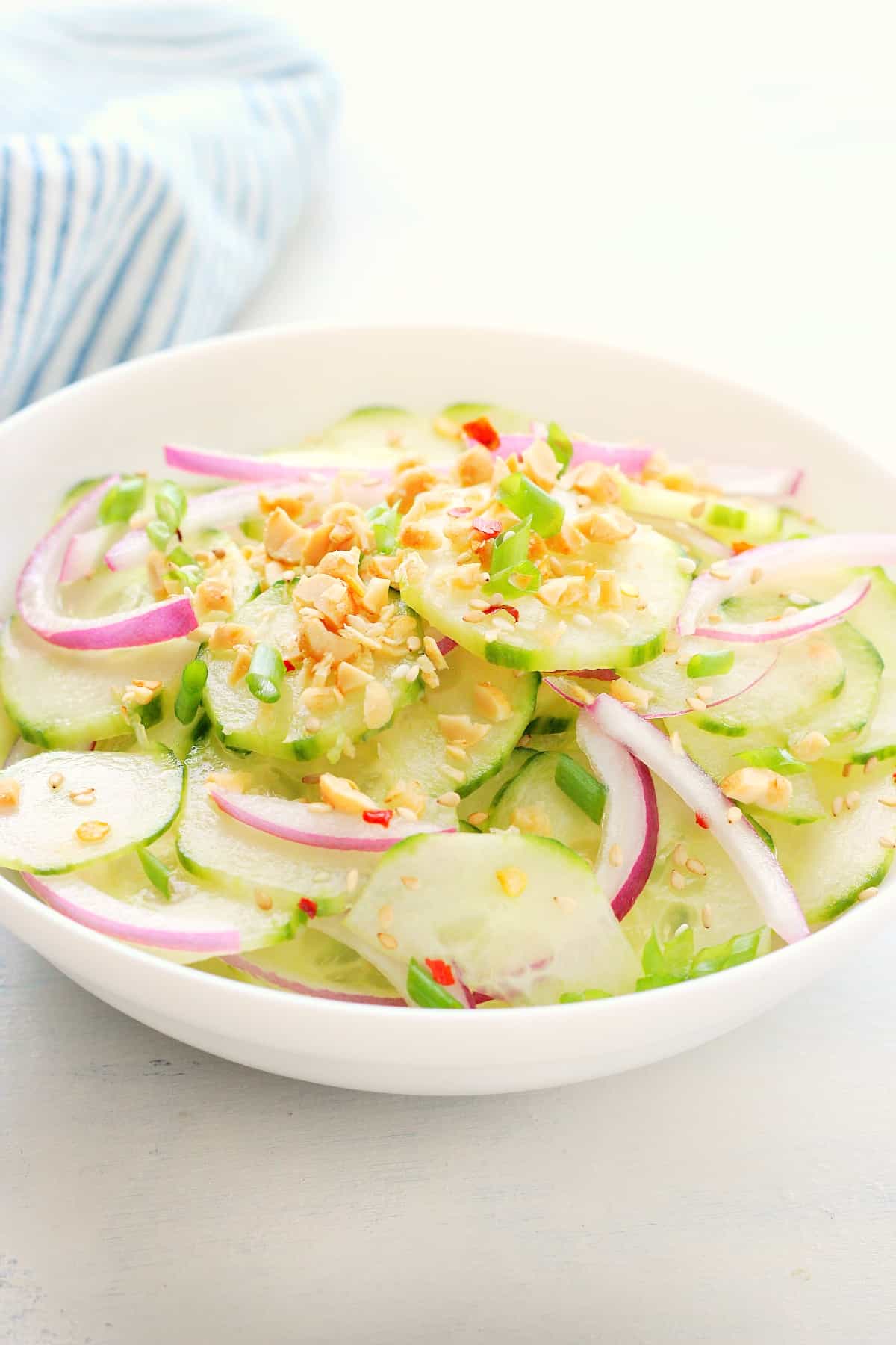 Cucumber salad in a white bowl.