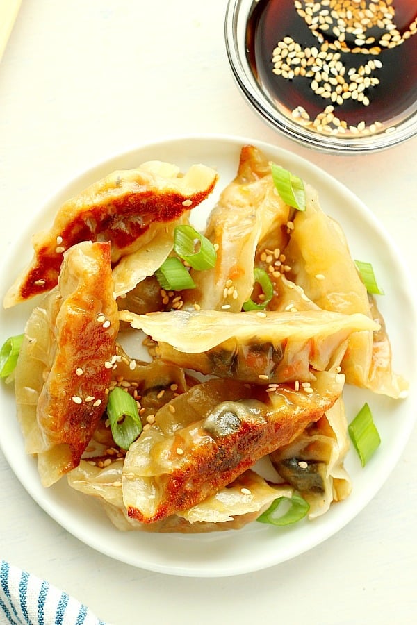 Pan-fried Asian dumplings on a plate.