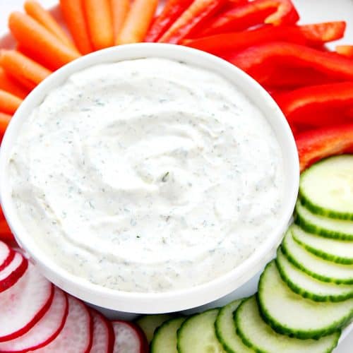 Dip in a bowl with veggies on plate.