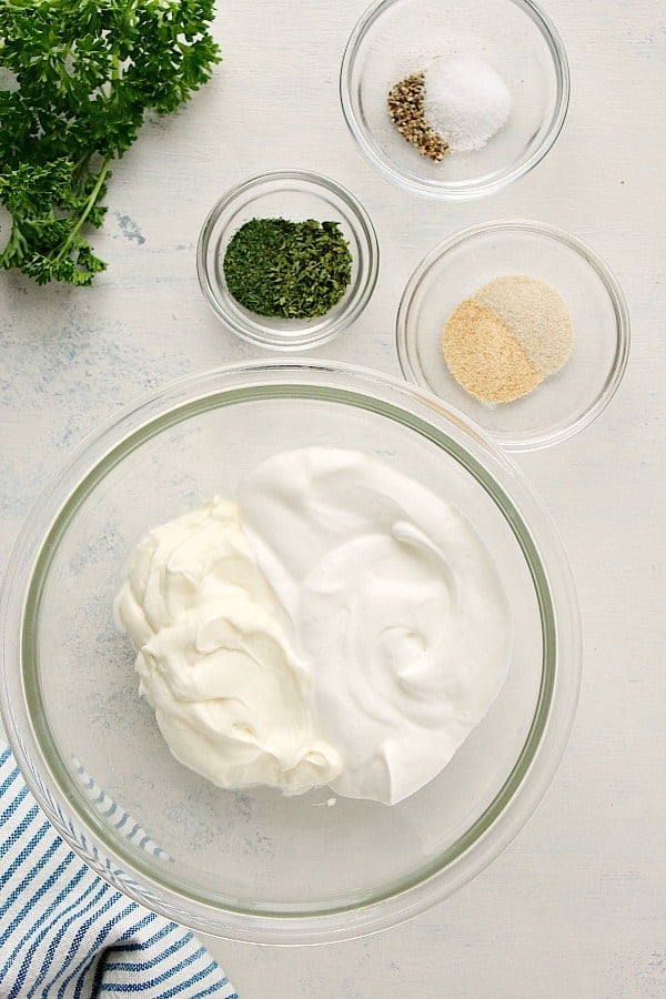 Ingredients for vegetable dip on a white board.