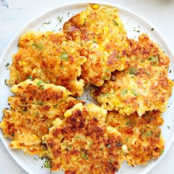 Corn fritters on a white plate.