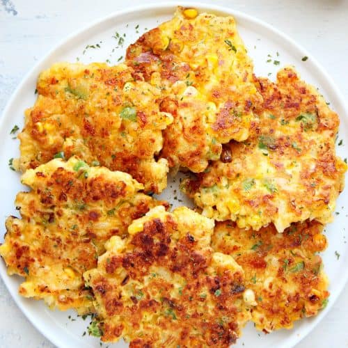 Corn fritters on a white plate.