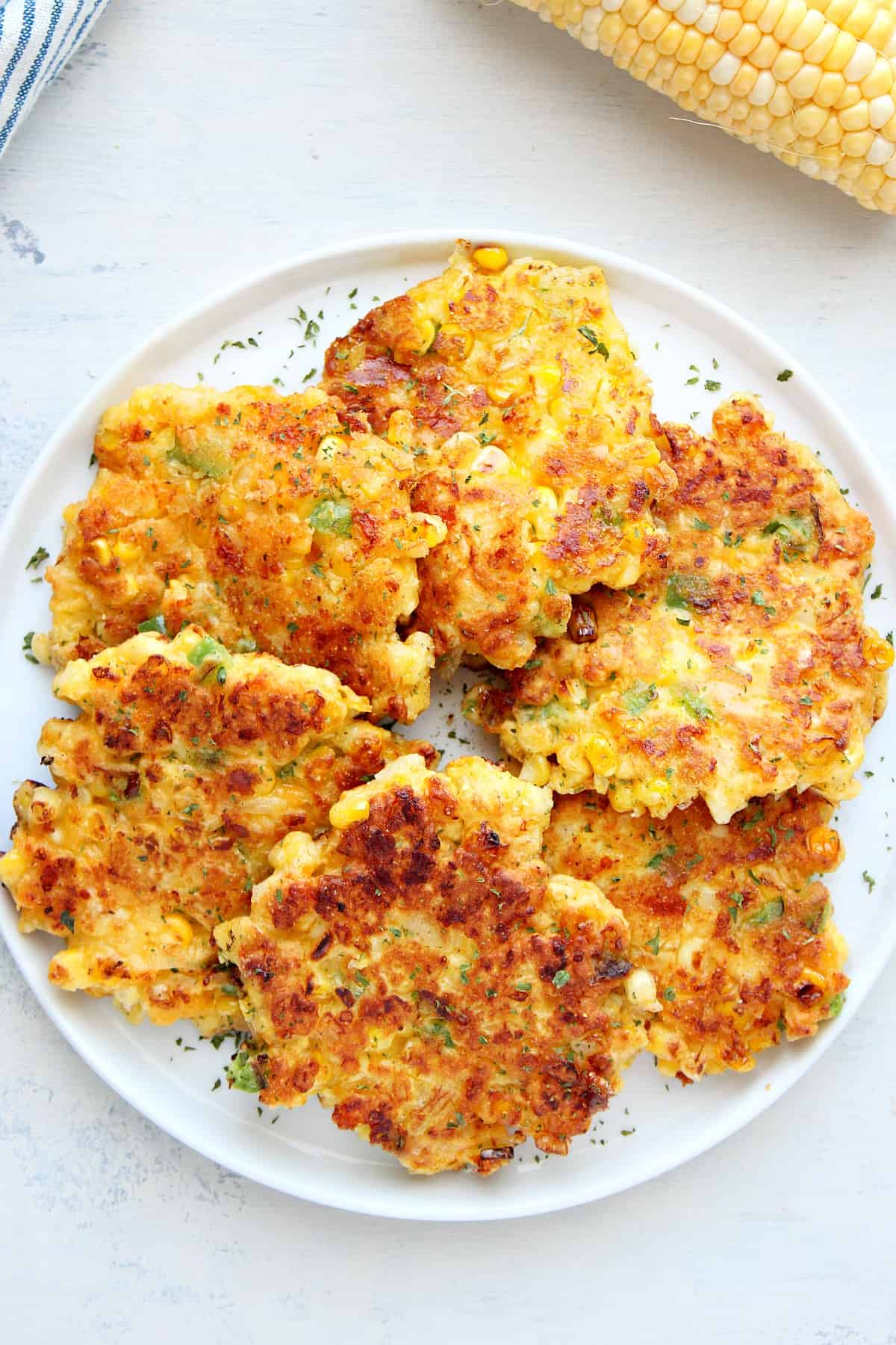 Corn fritters on a white plate.