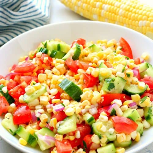 Corn, tomatoes and cucumber in a bowl.
