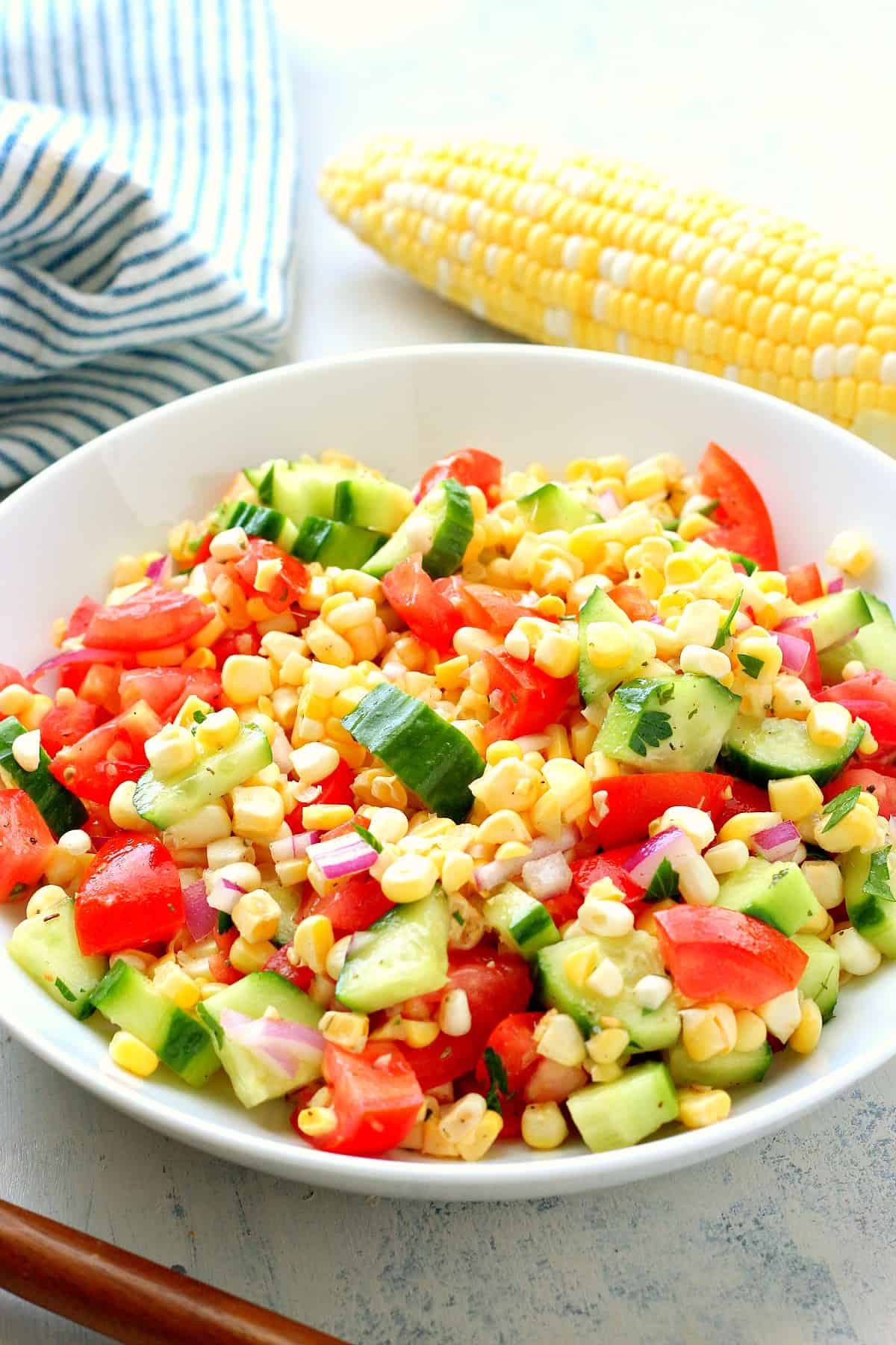 Corn, tomatoes and cucumber in a bowl.