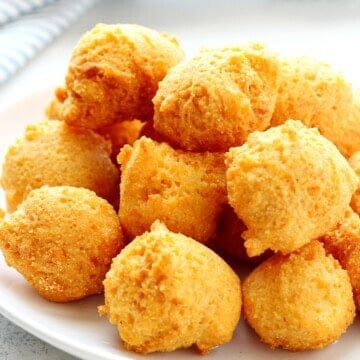Fried hush puppies on a white plate.