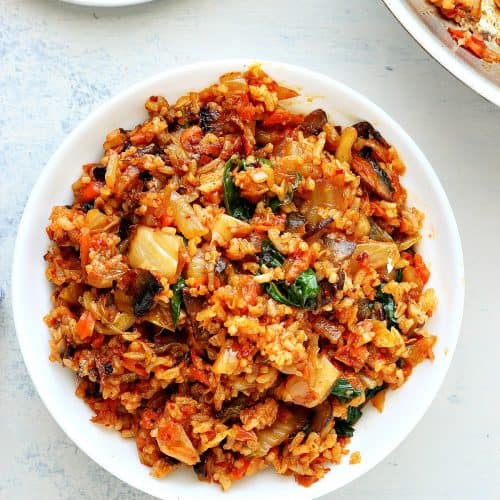 Rice with kimchi in a white bowl.