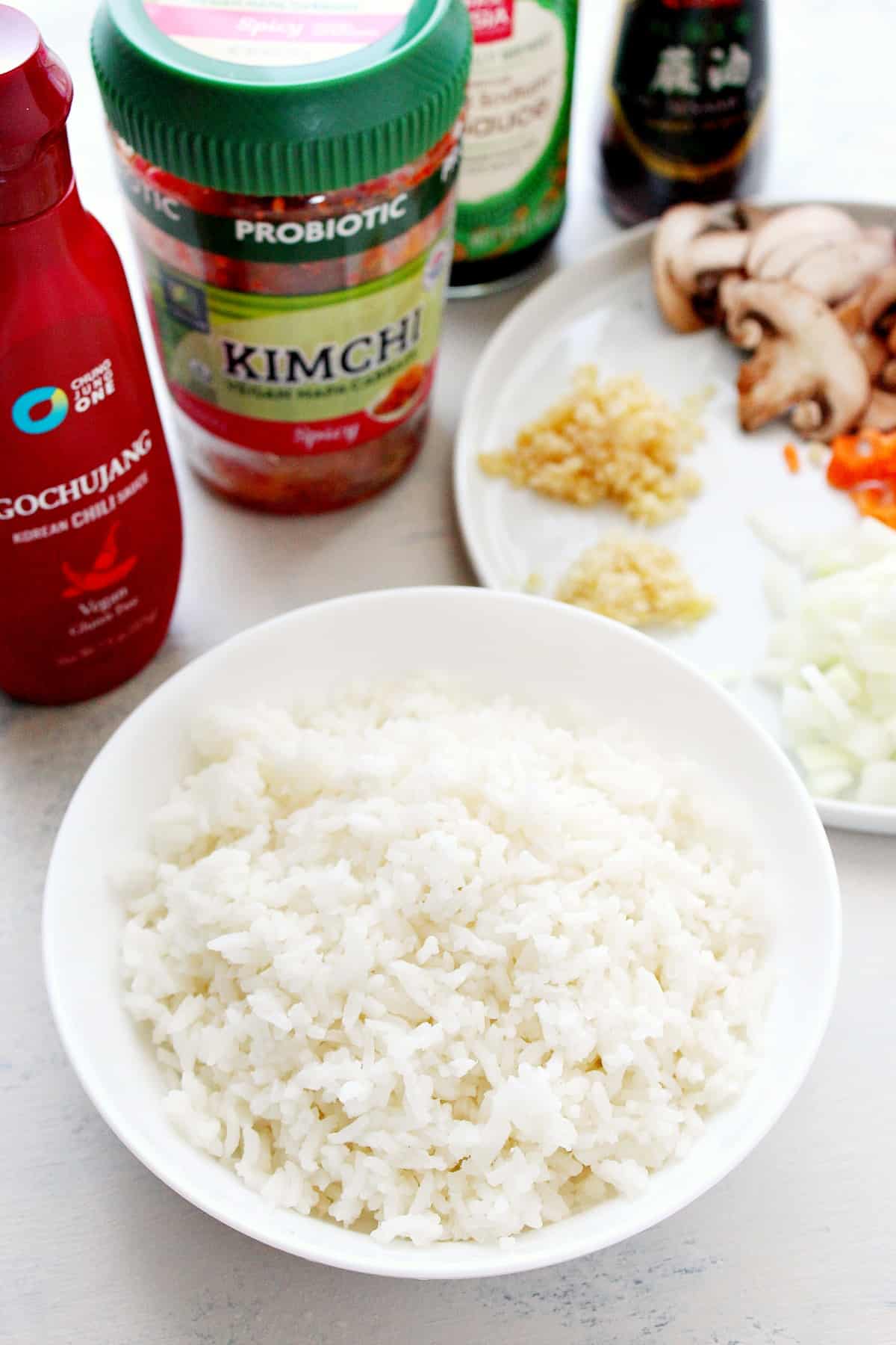 Ingredients for kimchi fried rice on a white board.