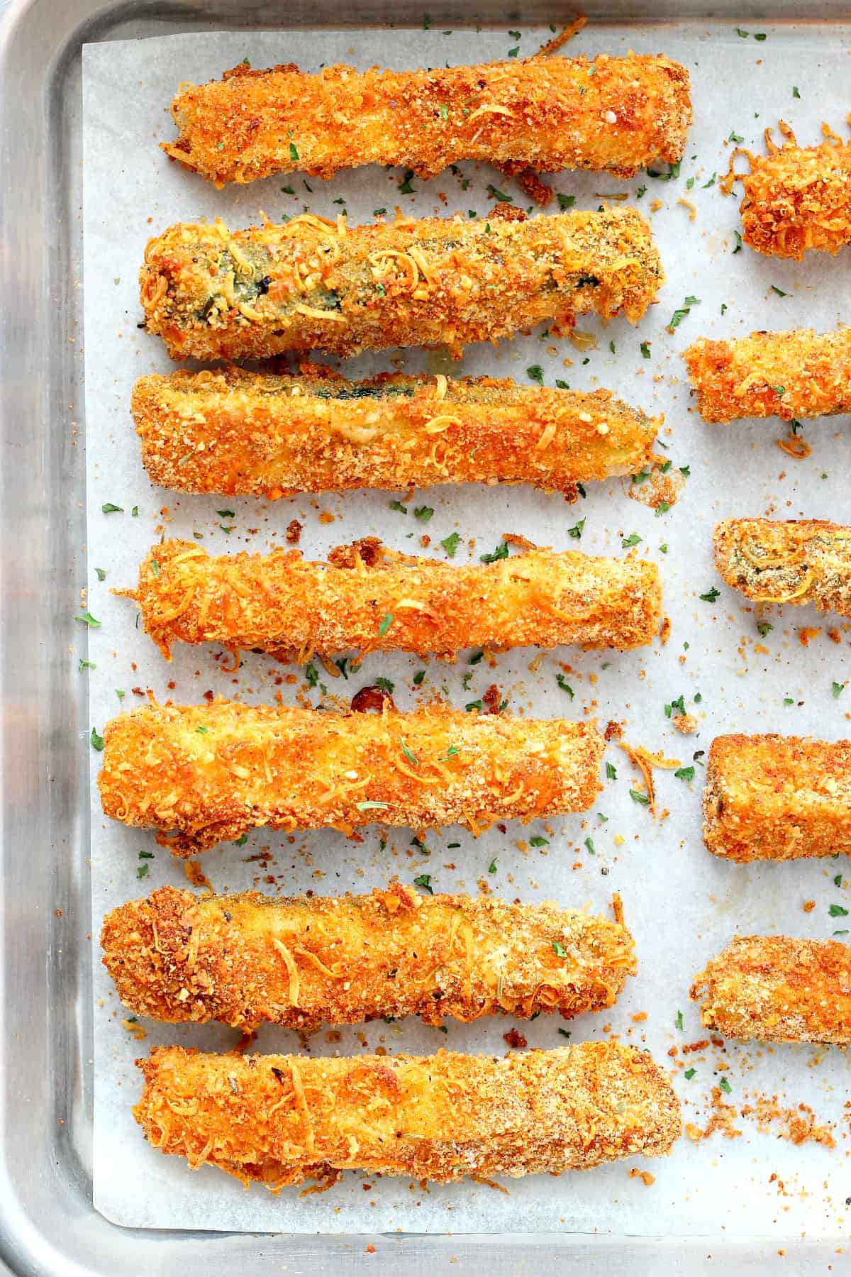 Baked zucchini fries on a baking sheet.