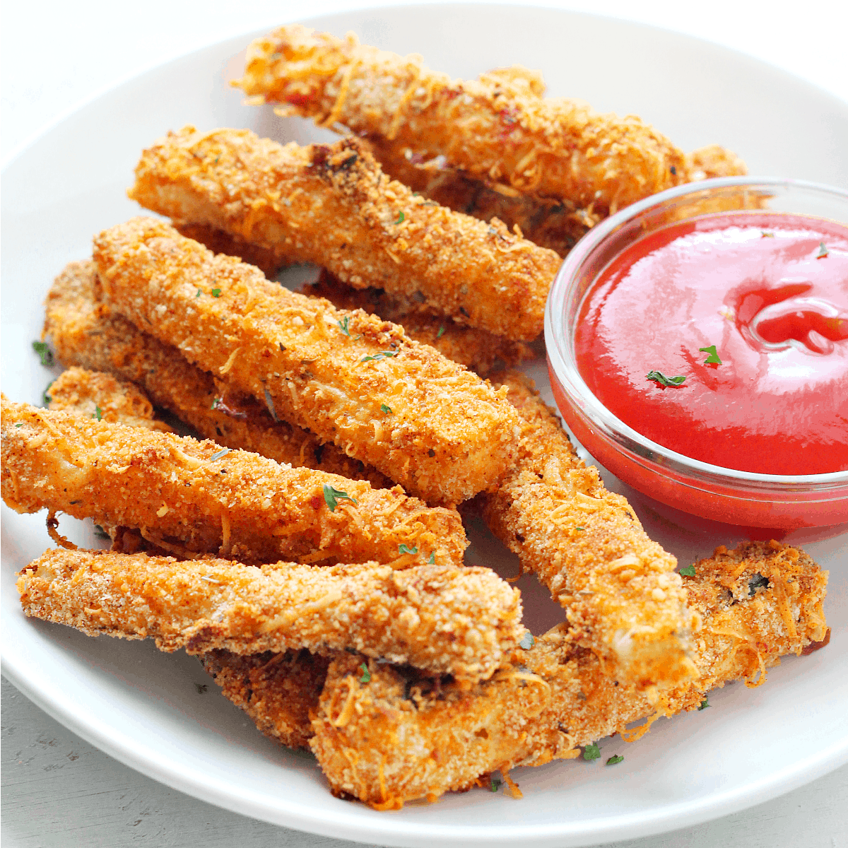 Zucchini fries on a plate with ketchup.