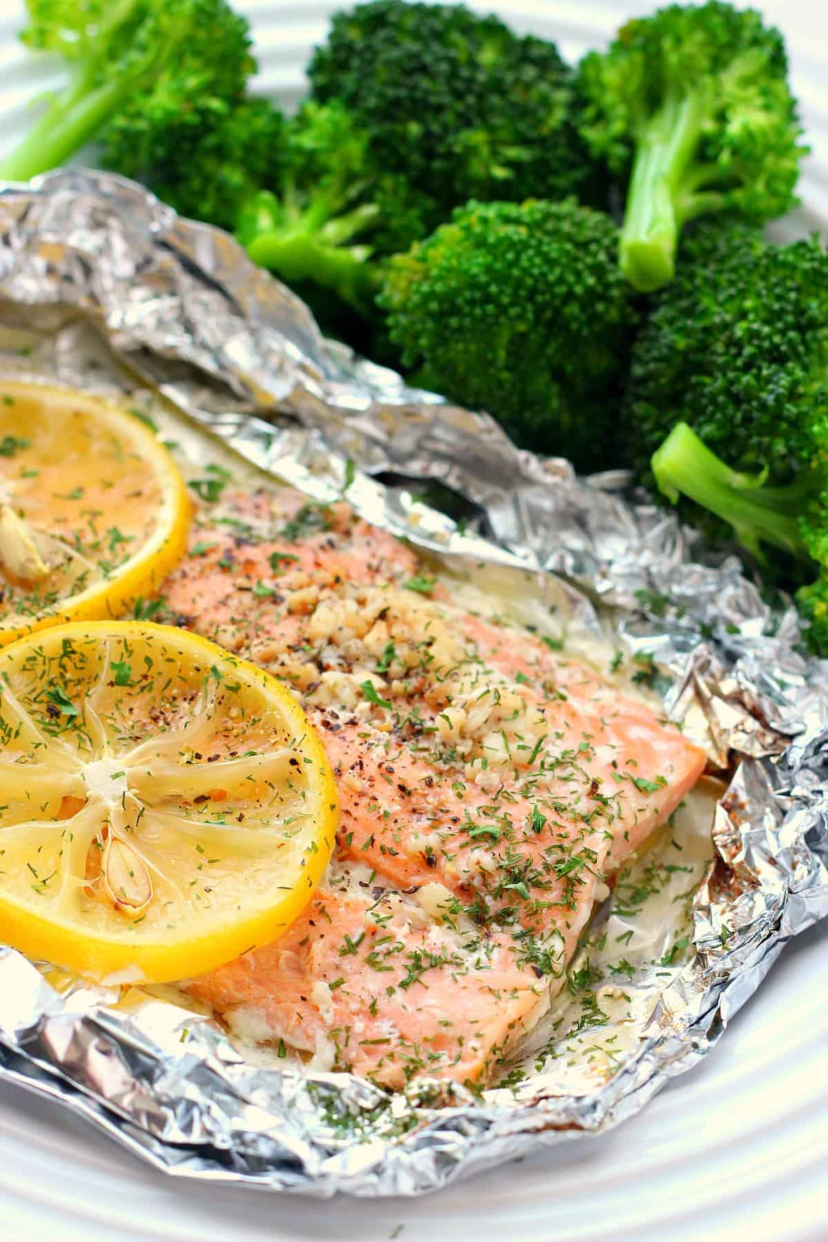 Salmon with lemon slices on a foil.